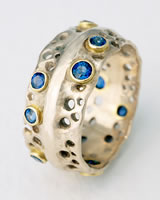 'Pierced Ring' in silver with small blue Sapphires
